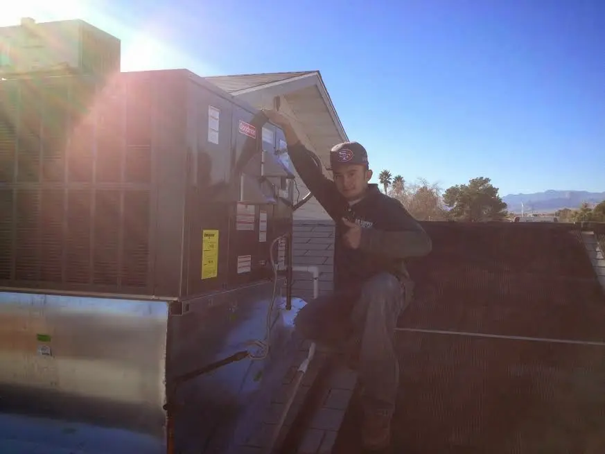 HVAC technician performing HVAC Inspection on a rooftop unit in Hebron